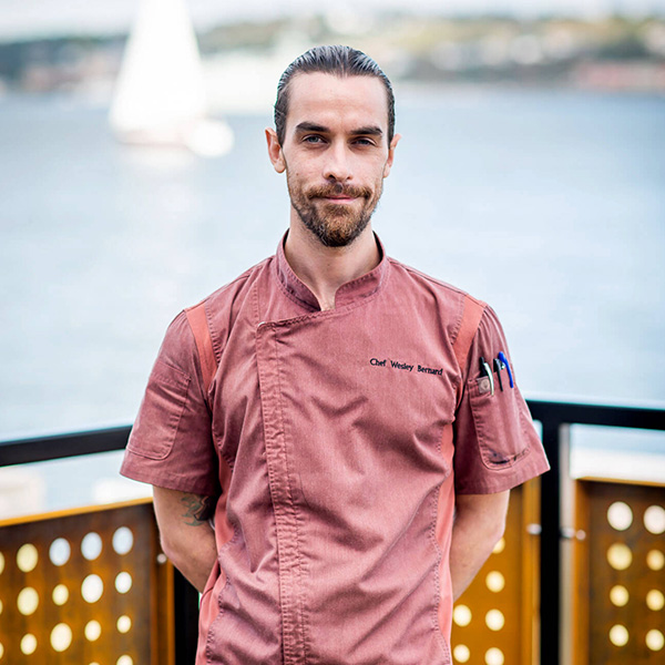 Headshot of Chef Wesley Bernard standing in front of the water